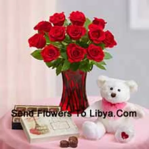 12 Red Roses With Some Ferns In A Glass Vase, A Cute 12 Inches Tall White Teddy Bear And An Imported Box Of Chocolates