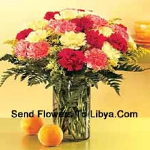 24 Mixed Colored Carnations With Seasonal Fillers In A Glass Vase