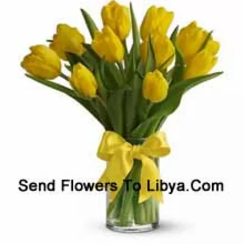 Yellow Tulips With Seasonal Fillers And Leaves In A Glass Vase - Please Note That In Case Of Non-Availability Of Certain Seasonal Flowers The Same Will Be Substituted With Other Flowers Of Same Value