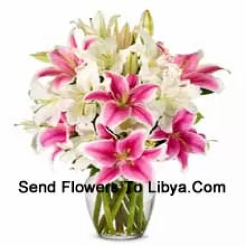 White And Pink Lilies With Some Ferns In A Glass Vase