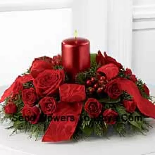 Ein karmesinrotes Display von Weihnachtswärme und -freude. Reichhaltige rote Rosen und Sprayrosen, rote Hypericumbeeren und üppige festliche Grünpflanzen umgeben eine rote metallische Säulenkerze, um ein herzerwärmendes Zentrum zu schaffen. Geschmückt mit hellrotem Band wird dieses Design den Geist der Ferienzeit mit Stil und Anmut zu ihren Versammlungen und Feierlichkeiten bringen. (Bitte beachten Sie, dass wir uns das Recht vorbehalten, jedes Produkt durch ein geeignetes Produkt von gleichwertigem Wert zu ersetzen, falls ein bestimmtes Produkt nicht verfügbar ist)